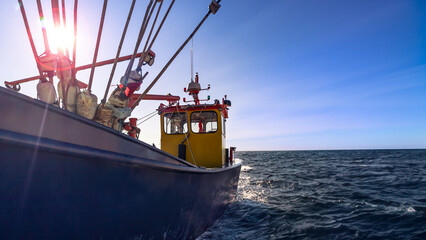 Fishing trawler in the sea on a background of blue sky © jarizPJ