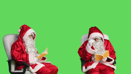 Santa claus reading fiction book in studio, enjoying literature or poetry lecture for knowledge....