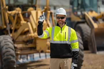Builder in helmet with excavator for construction at the construction site. Machinery tractor with...