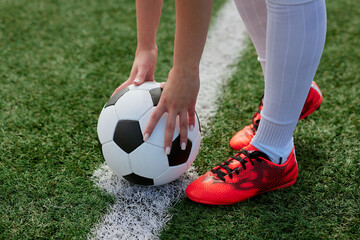 sports girl football player with a soccer ball on the soccer field, the concept of professional...