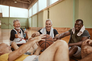 Senior men taking a break from playing basketball in an indoor gym