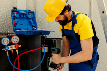 Knowledgeable professional using pneumatic drill to fix system electrical problems caused by...