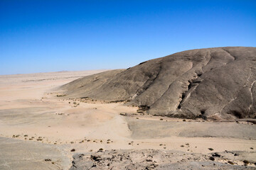Rocky sloping deserted mountain in the desert. Environmental dehydration and global warming