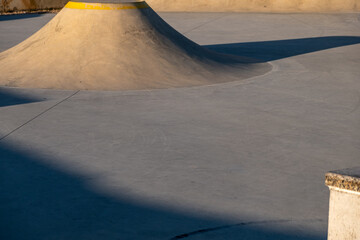 Detail of a public playground for a skateboard in a recreation park on sunset