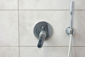 Dirty calcified shower mixer tap, faucet with limescale on it, plaque from hard water, Chrome...
