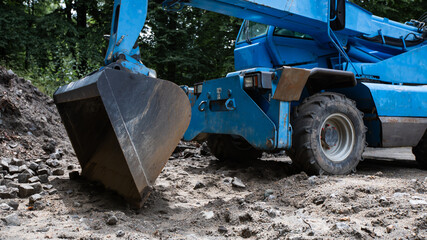 niebieskia koparka, ładowarka, ładuje kostke brukową, excavator, loader - obrazy, fototapety, plakaty