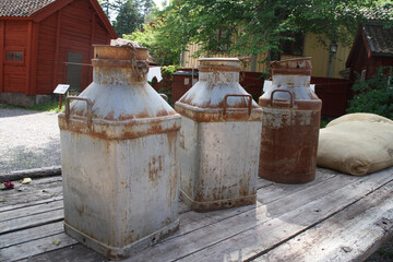 Obraz premium three old rusty milk containers