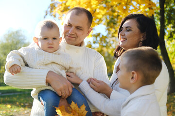 Family playing in autumn park having fun