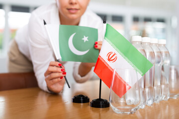 Little flag of Iran on table with bottles of water and flag of Pakistan put next to it by positive...