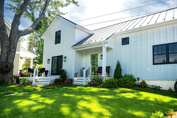 small two-story residential building with white siding. mowed lawn and manicured frontyard.