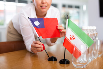 Little flag of Iran on table with bottles of water and flag of Taiwan put next to it by positive...