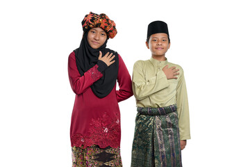 A young couple of a malay teenager girl wearing a traditional Negeri Sembilan costume and a boy wearing a baju melayu isolated on white background