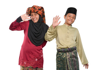 A young couple of a malay teenager girl wearing a traditional Negeri Sembilan costume and a boy wearing a baju melayu isolated on white background