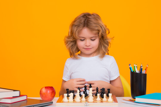 Child play chess on isolated background. Child think about chess game. Intelligent, smart and clever school kid pupil. Games for brain intelligence concept.