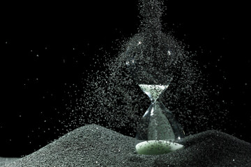 Hourglass add more sand of time on white sand over black background. White hourglass show more time...