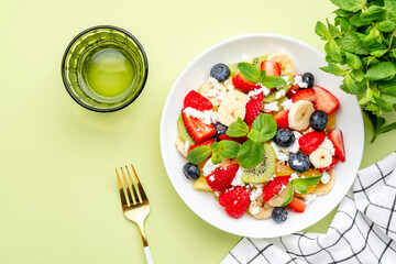 Summer fruit and berry salad with feta cheese, fresh strawberries, blueberries, banana, kiwi,...