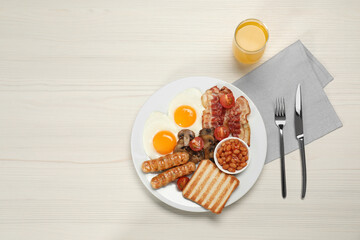Plate of fried eggs, sausages, mushrooms, beans, bacon and toast on white wooden table, flat lay...