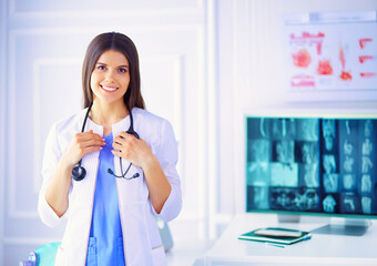 Portrait of a beautiful doctor standing at hospital and holding her stethoscope