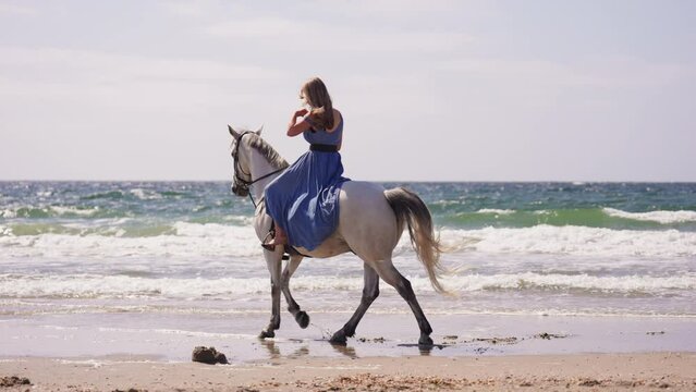 Girl In Blue Dress Horse Riding At The Beach