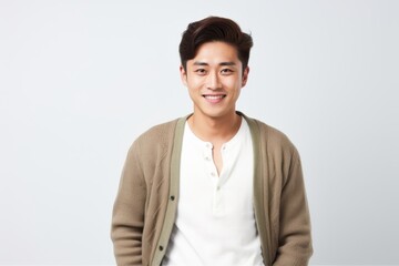 Fototapeta premium Portrait of a happy young asian man standing over white background