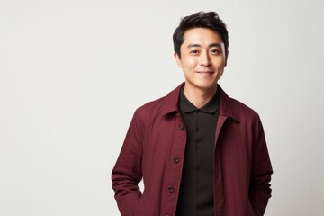 Fototapeta premium Portrait of a happy young Asian man standing over white background.