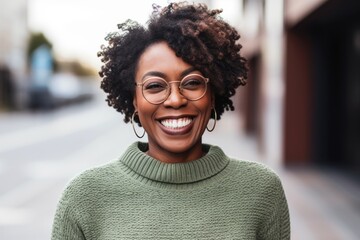 Portrait of a smiling young african american woman in eyeglasses outdoors