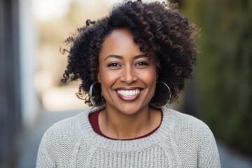 Portrait of smiling african american woman with curly hair in city