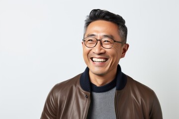 Fototapeta premium Portrait of a happy young asian man smiling against white background