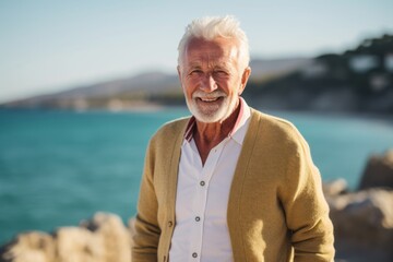 Fototapeta na wymiar Portrait of smiling senior man standing by sea on a sunny day