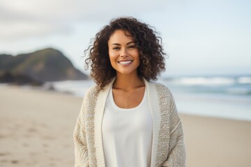 Portrait of smiling young woman standing on beach at the day time