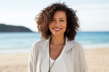Portrait of a smiling young woman standing on the beach at the day time