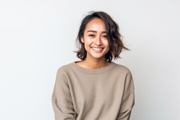 Obraz premium Smiling young Asian woman in sweater standing and looking at camera.