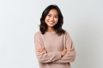 Fototapeta premium Portrait of a smiling young asian woman with arms crossed on white background