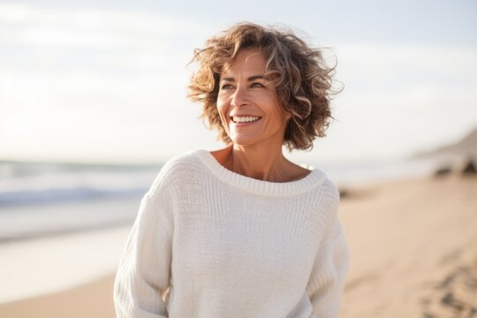 Portrait of beautiful middle aged woman smiling at camera on the beach
