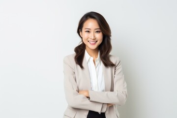 Portrait of a smiling businesswoman standing with arms crossed on white background