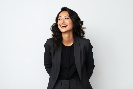 Lifestyle portrait photography of a pleased Indonesian woman in her 30s wearing a sleek suit against a white background 