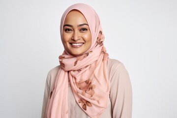 Portrait of muslim woman in hijab smiling at camera over white background