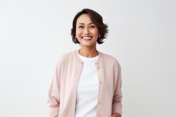 Portrait of smiling businesswoman standing with hand in pocket against white background