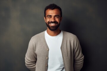 Obraz premium Handsome young African man smiling and looking at camera while standing against grey background