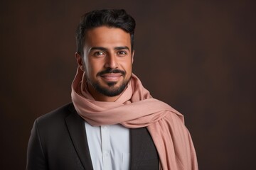 Obraz premium Portrait of handsome Indian man in turtleneck and scarf against brown background