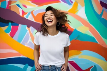 Fototapeta premium Portrait of beautiful young asian woman laughing on colorful graffiti background