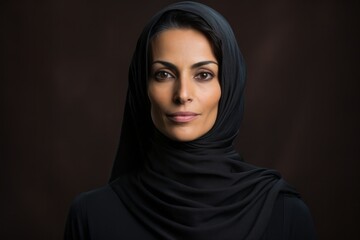Naklejka premium Portrait of a beautiful muslim woman wearing hijab over dark background