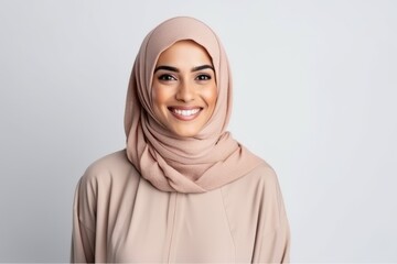 Portrait of beautiful young muslim woman wearing hijab smiling at camera