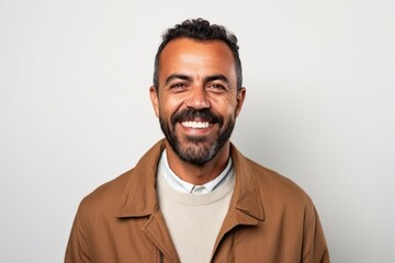 Obraz premium Handsome bearded Indian man with brown jacket smiling at the camera