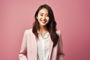 Fototapeta premium Portrait of a beautiful young asian businesswoman on pink background