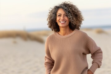 Portrait of a smiling young woman with curly hair on the beach