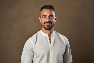 Obraz premium Portrait of handsome bearded Indian man in white shirt looking at camera