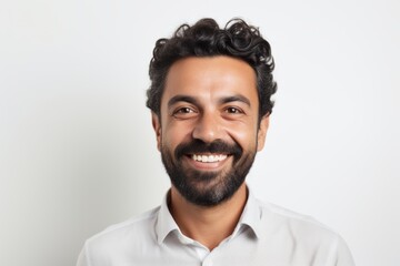 Obraz premium Portrait of happy young bearded Indian man smiling at camera. Isolated on white background.