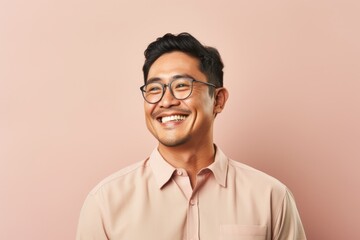 Obraz premium Portrait of happy asian man in eyeglasses on pink background