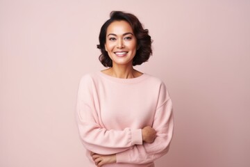 Obraz premium Portrait of a beautiful young woman smiling and looking at camera isolated over pink background